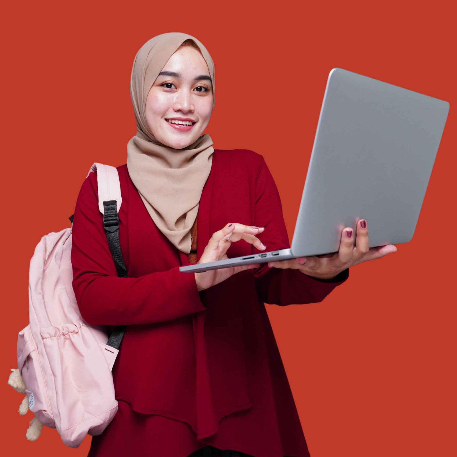 Woman holding a laptop with a pink backpack on a red background