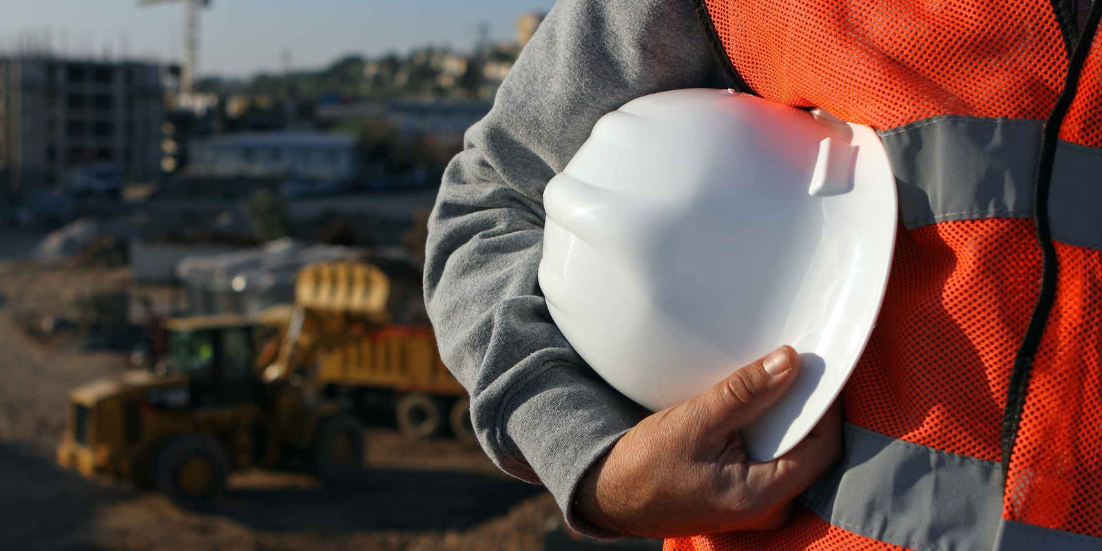 image of tradesman holding a white hard hat