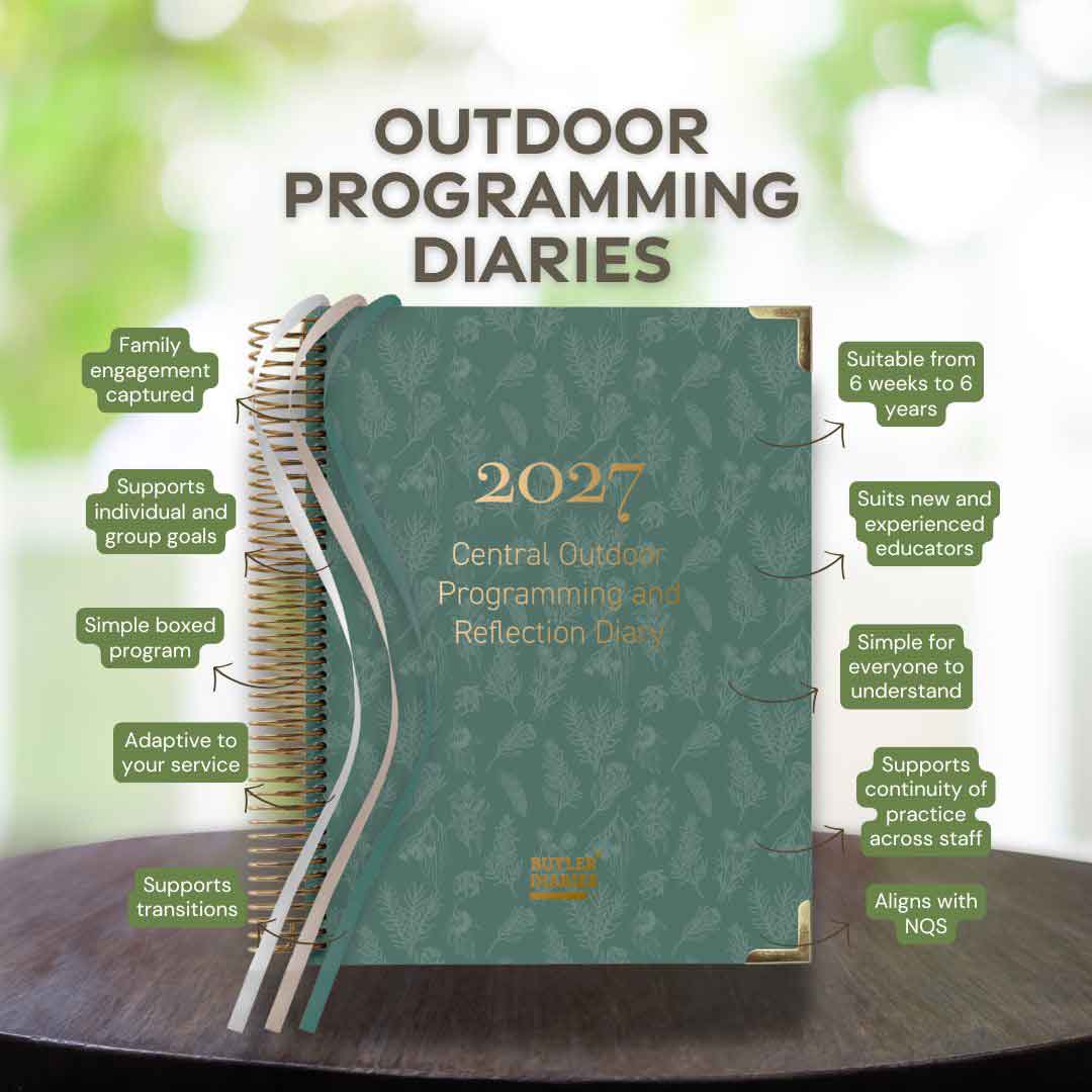 Green programming diary with text on a wooden surface and blurred greenery in the background