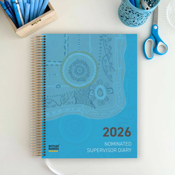 Blue spiral-bound diary labeled '2026 Nominated Supervisor Diary' on a white surface with stationery items.