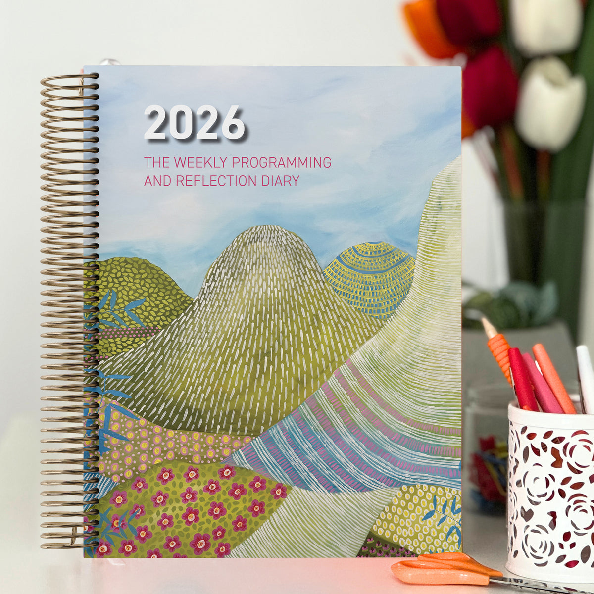 EYLF Weekly Programming and Reflection Diary with Glasshouse Mountains Artwork Cover sitting on desk in ECEC