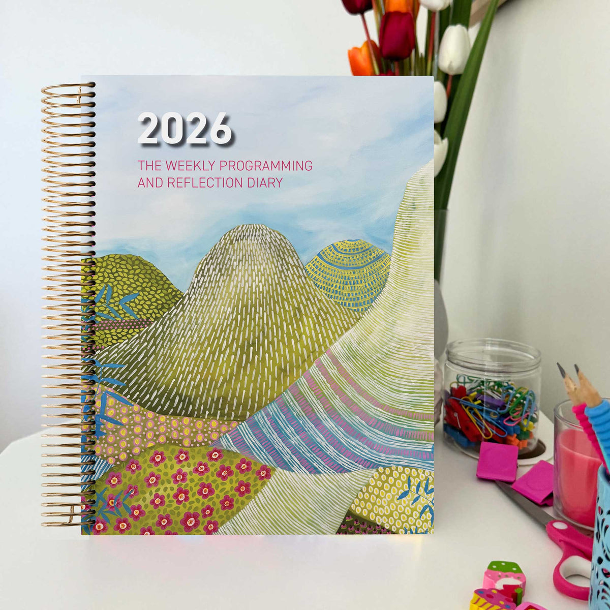 EYLF Weekly Programming and Reflection Diary with Glasshouse Mountains Artwork Cover sitting on Educator's desk