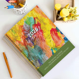 Central Outdoor Weekly Programming and Reflection Diary for EYLF with Child Artwork Cover sitting on an outdoor ECEC table