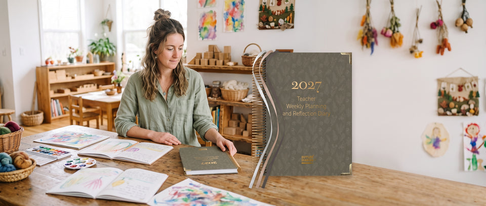  A woman sits at a wooden table in a bright, decorated children's room, looking at a slim hardcover journal. A large, digitally composited overlay of the same journal appears on the right side.