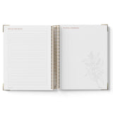 Open spiral-bound notebook with lined pages on a white background