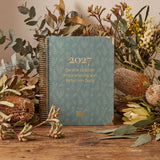 2027 diary with floral and plant decorations on a wooden surface