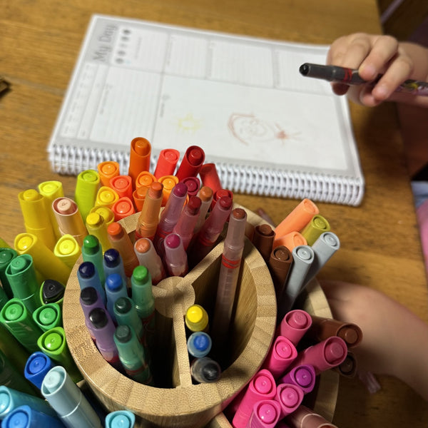 A child completing the Children's Voices Diary using colourful crayons