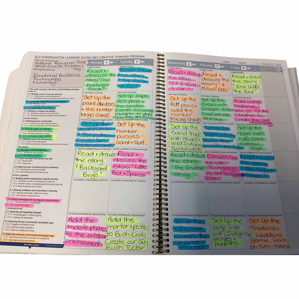 Open Educator Programming Diary with colorful notes and highlights on a white surface