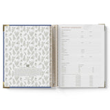 Open spiral-bound ECEC Cook Diary with floral pattern on one page and text on the other, on a white background.