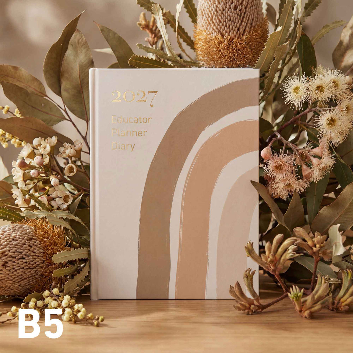 2027 Educator Planner diary with decorative elements on a wooden surface