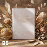 Book titled 'Professional Development' with decorative elements on a wooden surface