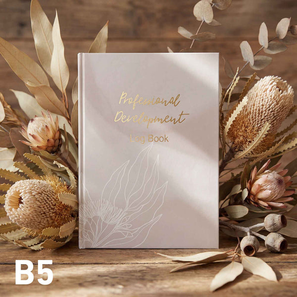 Book titled 'Professional Development' with decorative elements on a wooden surface