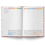 Open planner showing monthly layout with colorful headers on a white background
