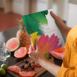 Person holding a colorful planner with a fruit background