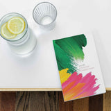 Colorful planner diary on a white surface with a glass of water and lemon slices.