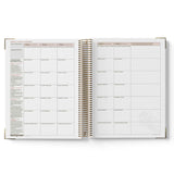 Open planner with weekly schedule on white background
