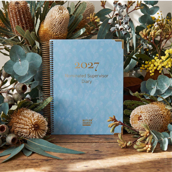 2027 2027 Nominated Supervisor Diary with floral decorations on a wooden surface