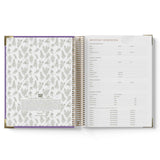 Open spiral-bound 2027 OSHC Diary with floral pattern on left page and text on right page.