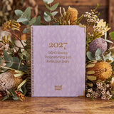 2027 diary with floral decorations on a wooden surface