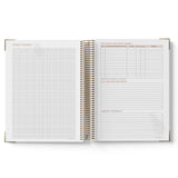 Open spiral-bound planner with grid and lined pages on a white background
