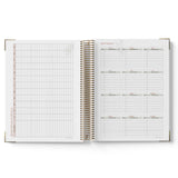 Open spiral-bound QLD Kindy Programming Diary with grid and list pages on a white background