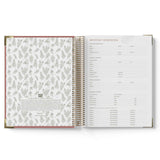 Open spiral-bound QLD Kindy Programming Diary with floral pattern on left page and text on right page.