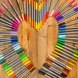 Colorful markers arranged in a circular pattern on a wooden surface