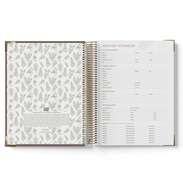 Open spiral-bound book with floral pattern on one page and text on the other, on a white background.