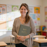 primary school teacher holding a butler diary in classroom